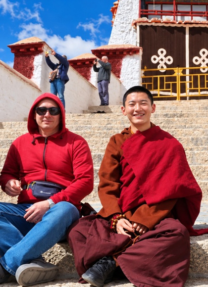 Reisender mit einem tibetischen M&ouml;nch auf den Stufen des Potala-Palastes in Lhasa