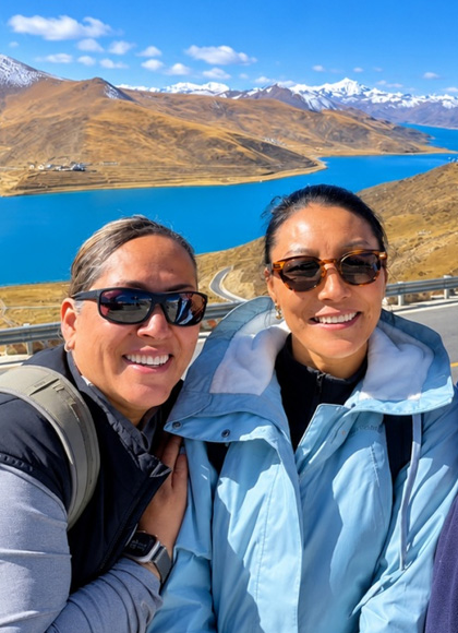 Drei Reisende bei einem Fotostopp am Yamdrok-See in Tibet
