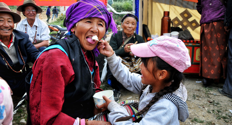 Einheimische Tibeter essen im Kloster Drepung Joghurt, um das Schotten-Festival zu feiern