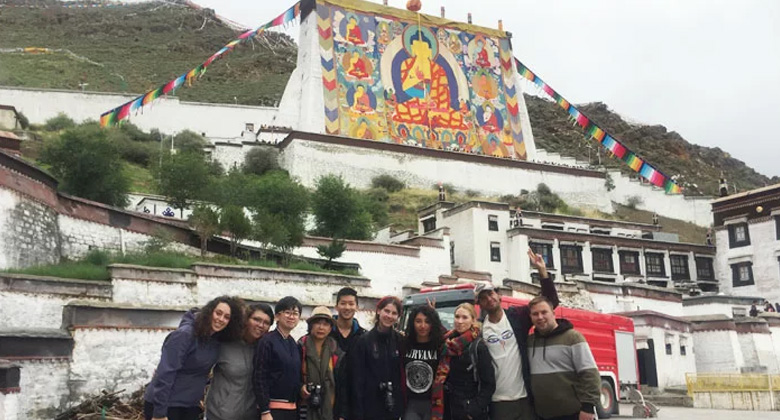 G&auml;ste vor riesigen Buddha-Thangkas beim Tashilhunpu-Kloster-Festival in Shigatse