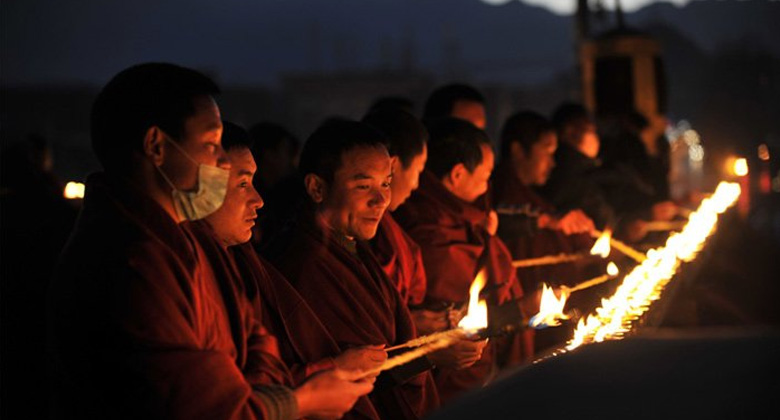 Tibetische M&ouml;nche entz&uuml;nden Butterlampen beim Tsongkhapa-Butterlampenfest in Lhasa