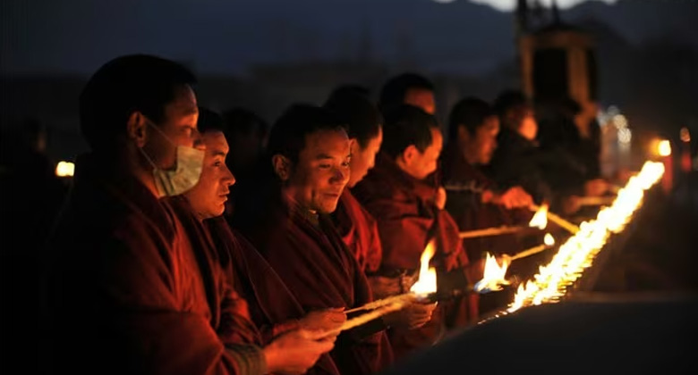 Tibetische Mönche zünden Butterlampen auf dem Dach des Jokhang-Tempels an