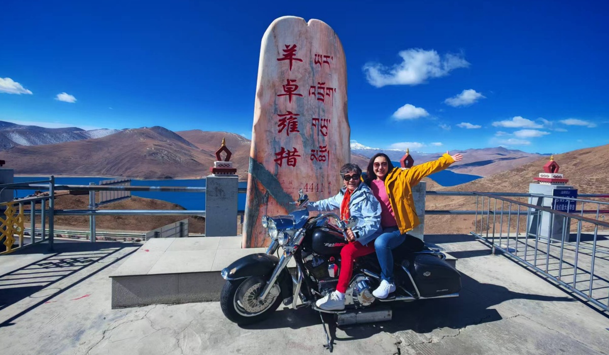 Reisende mit Motorrad am Yamdrok-See in Tibet