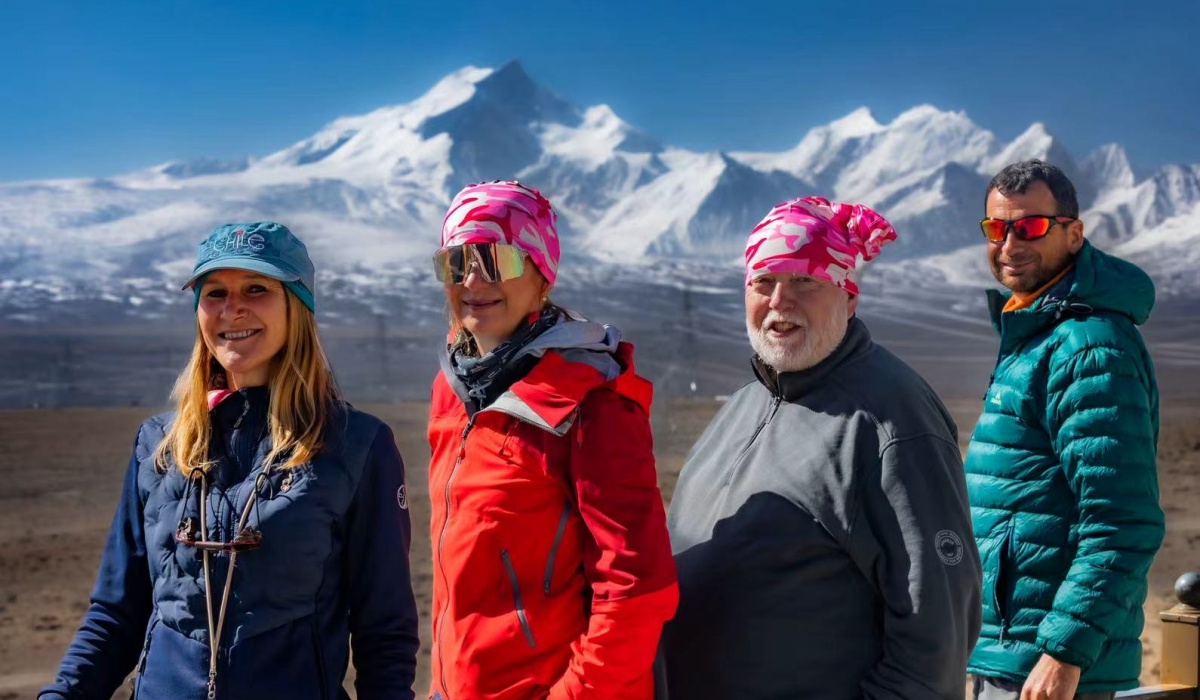 Reisegruppe vor schneebedeckten Bergen in Tibet