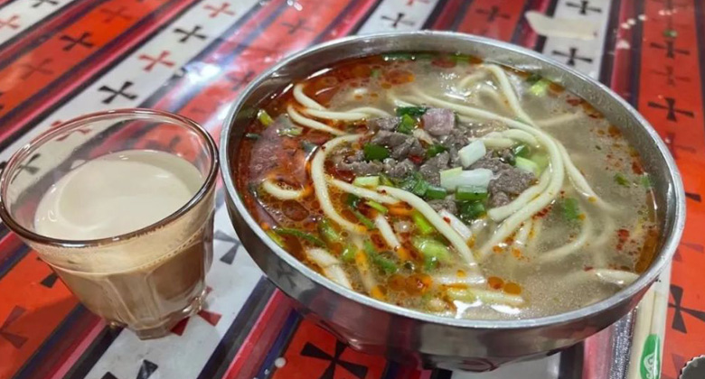 Am besten schmeckt der süße tibetische Tee zusammen mit traditionellen tibetischen Gerichten wie tibetischen Nudeln