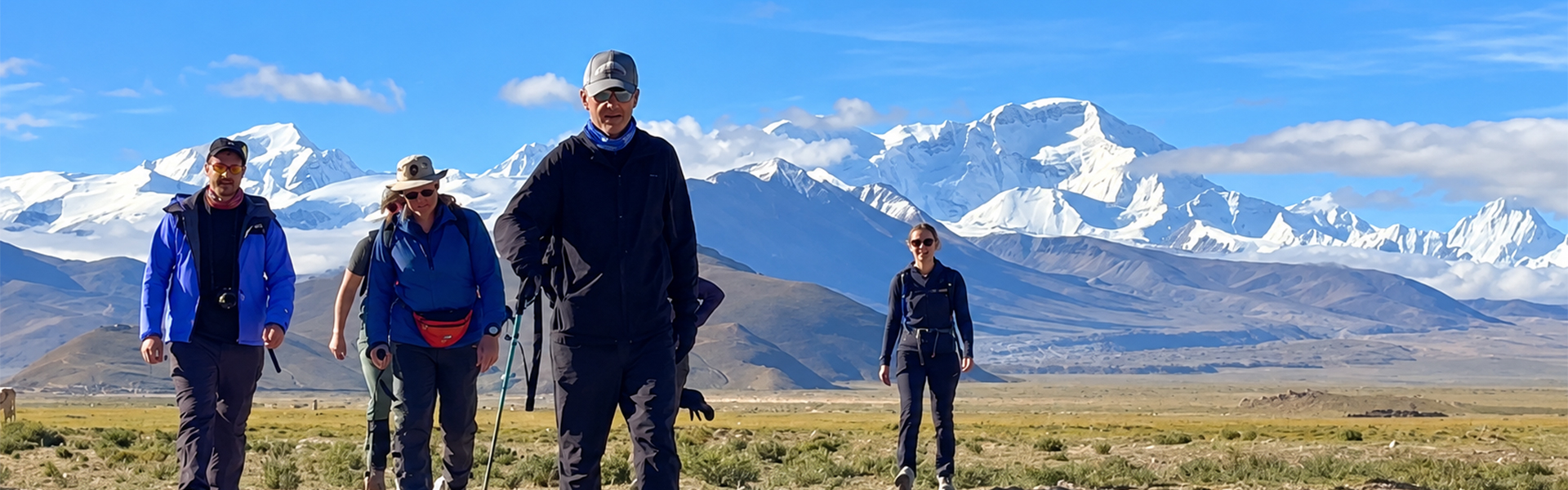 Reisegruppe beim Everest-Trekking in Tibet vor schneebedeckten Himalaya-Gipfeln