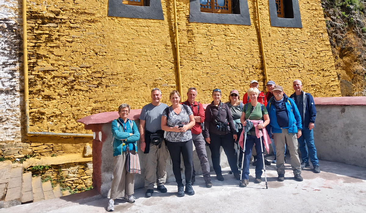 Reisegruppe beim Trekking an einem Kloster in Tibet