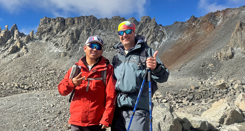 Tibetischer Trekking-Guide und Reisender in felsiger Berglandschaft